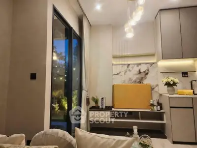 Modern living room with elegant lighting and stylish kitchen area, featuring a cozy ambiance and contemporary design.