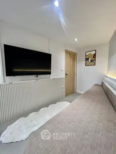 Modern living room with sleek TV and cozy sofa, perfect for relaxation.