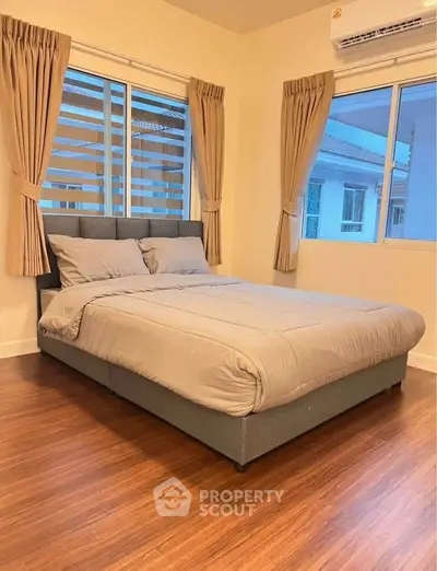 Cozy bedroom with modern decor and large windows for natural light