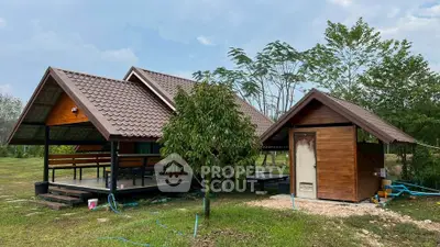 Charming rustic wooden house with sloped roofs and lush green surroundings, perfect for serene living.