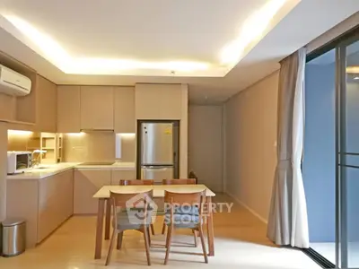 Modern kitchen with dining area, featuring sleek cabinetry and stainless steel appliances.