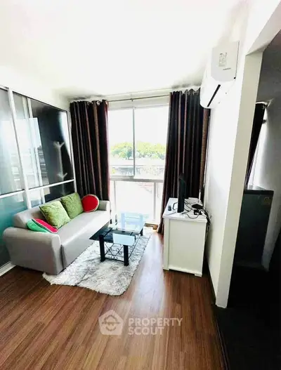 Charming living room with modern decor and large window offering natural light.