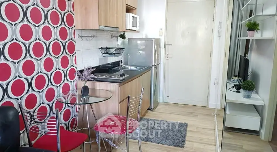 Modern compact kitchen with vibrant decor and dining area in cozy apartment