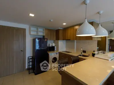 Modern kitchen with sleek appliances and stylish lighting in a contemporary apartment.