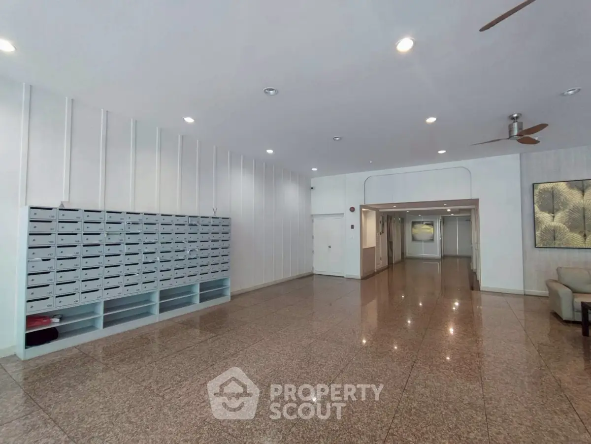 Spacious building entrance with mailboxes and polished flooring
