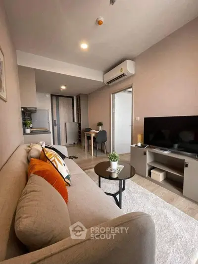 Modern living room with cozy sofa, TV unit, and dining area in open layout apartment.