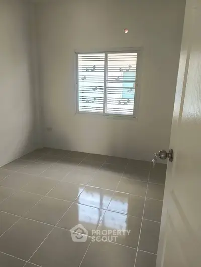 Bright empty room with tiled floor and window, perfect for customization.