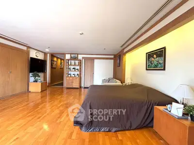 Spacious bedroom with wooden flooring and elegant decor