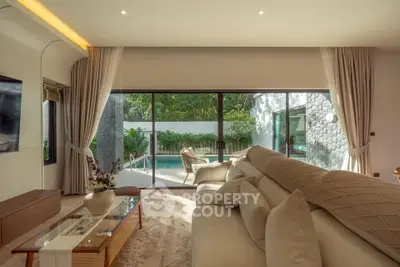 Luxurious living room with plush sofa and pool view, perfect for relaxation and entertaining.