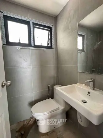 Modern bathroom with sleek fixtures and natural light from window.