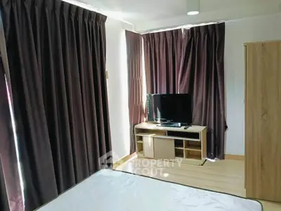 Cozy bedroom with TV and elegant curtains in modern apartment