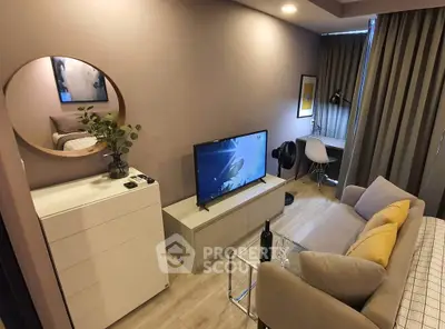 Modern living room with stylish decor, featuring a cozy sofa, flat-screen TV, and elegant furnishings.