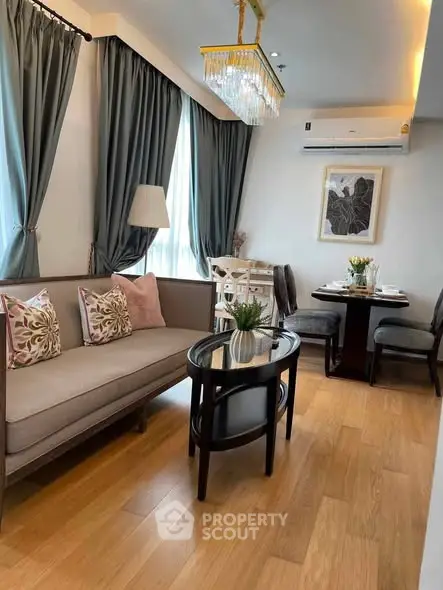 Elegant living room with modern decor, featuring a cozy sofa, stylish dining area, and chic lighting.