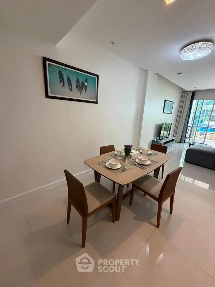 Modern dining area with elegant table setting and cozy living room view.