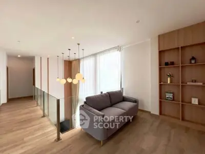 Modern living area with stylish sofa and elegant lighting in a bright, open space.