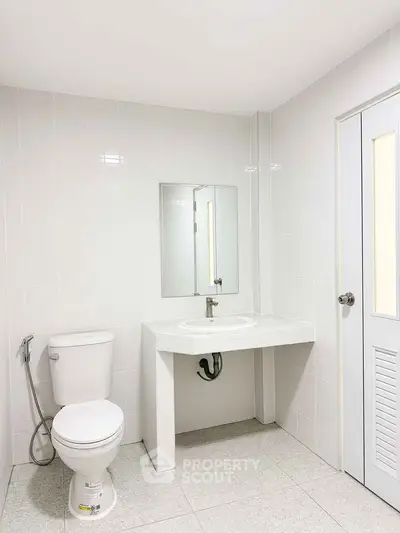 Modern minimalist bathroom with white tiles and sleek fixtures