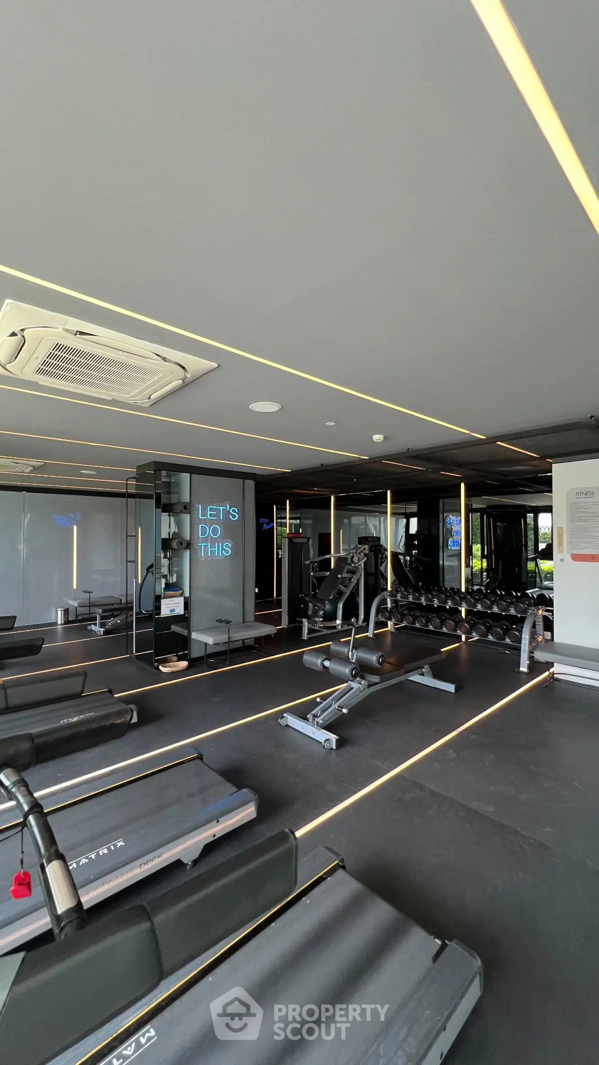 Modern gym with sleek equipment and motivational decor in luxury real estate property.
