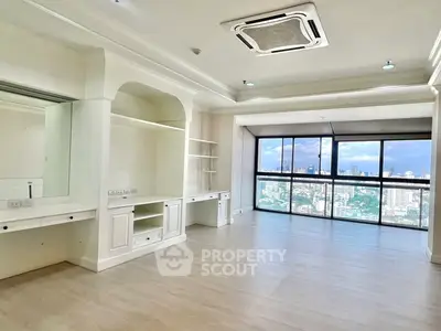 Spacious living room with panoramic city view and elegant built-in shelving.