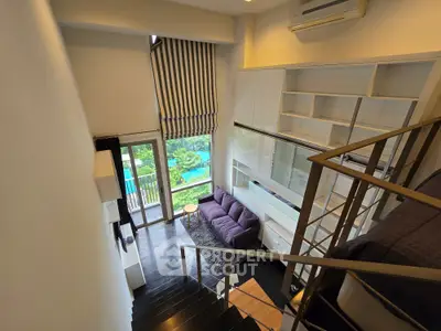 Modern loft apartment with high ceilings, large windows, and stylish interior design overlooking a lush green view.