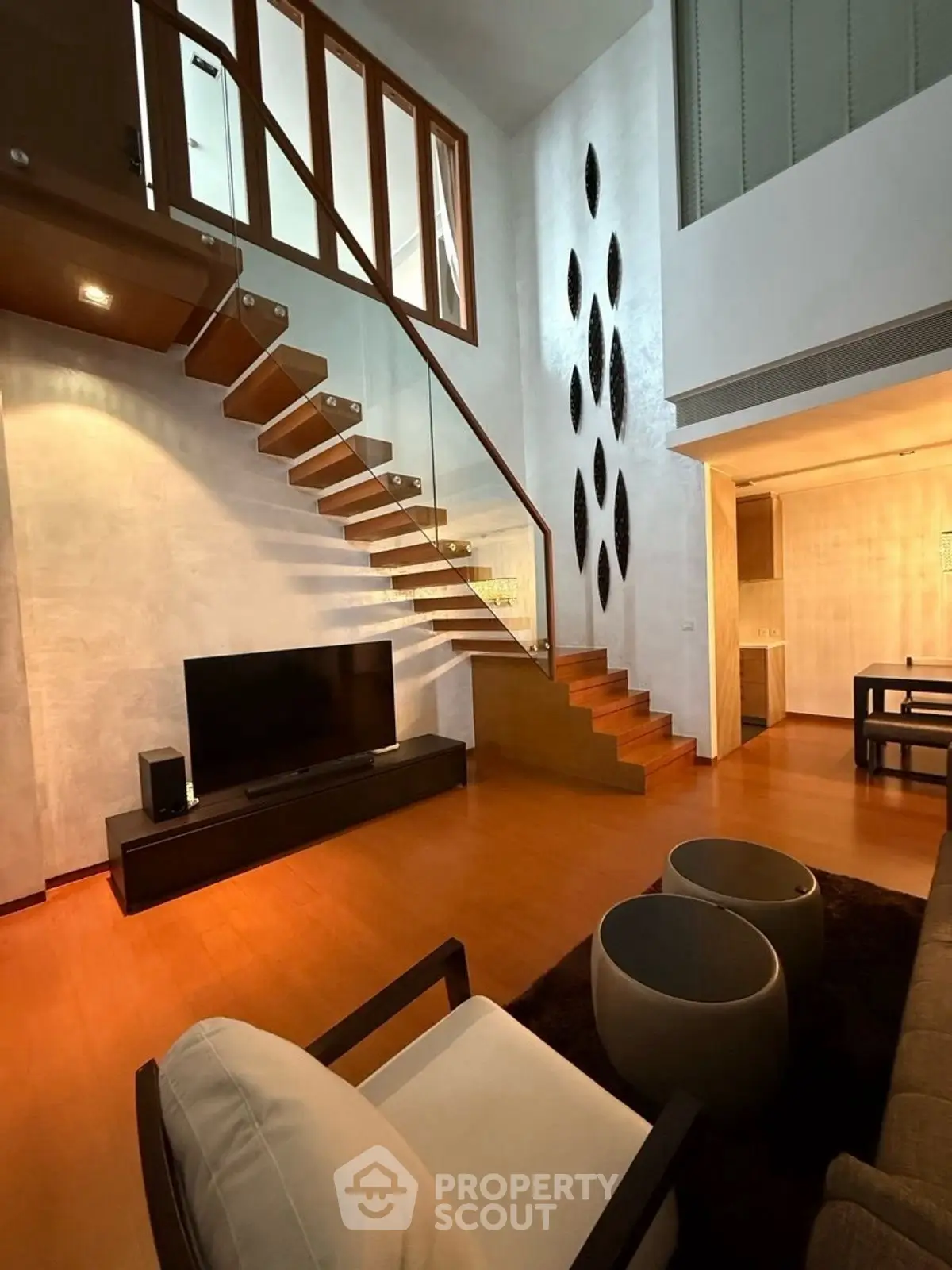 Luxurious modern living room with high ceilings and elegant staircase