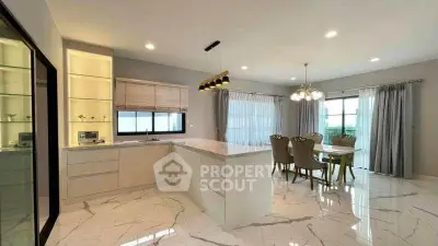 Luxurious open-layout kitchen and dining area with elegant marble flooring and modern lighting.