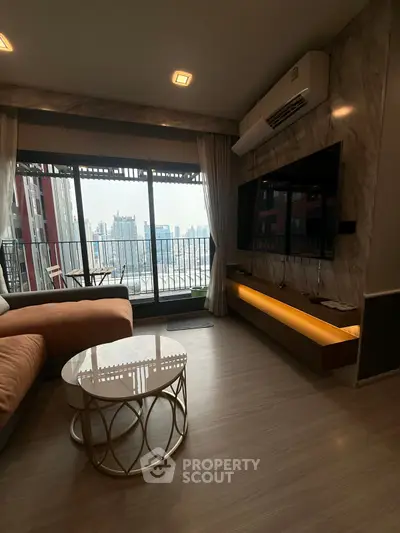 Modern living room with city view, large TV, and stylish furniture.
