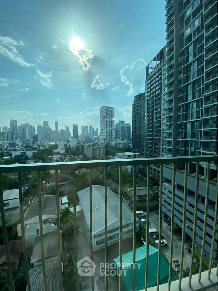 Stunning cityscape view from high-rise balcony with modern skyscrapers and clear blue sky.