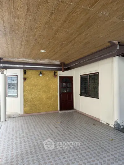 Spacious covered entrance with tiled flooring and wooden ceiling