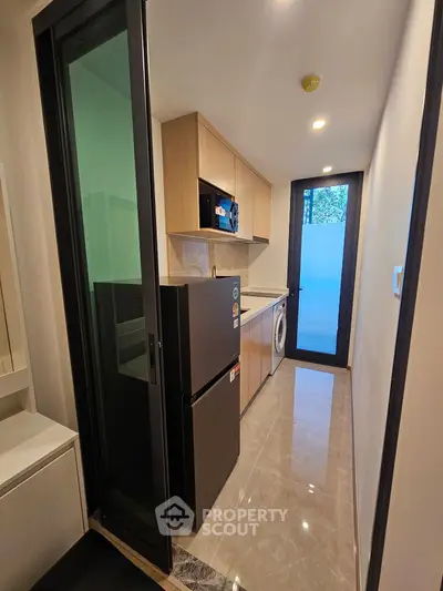 Modern kitchen with sleek appliances and ample storage in a compact layout.