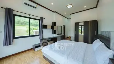 Spacious modern bedroom with scenic window view and elegant furnishings.