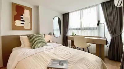Modern bedroom with stylish decor and large window, featuring a cozy bed and study desk.