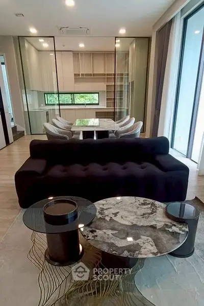 Luxurious modern living room with elegant furniture and large windows offering natural light.