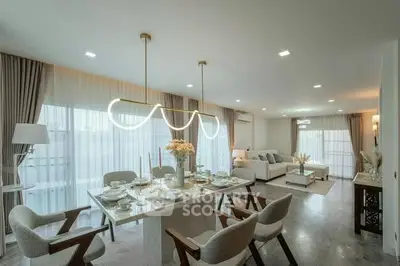 Luxurious open-plan living and dining area with modern decor and elegant lighting.