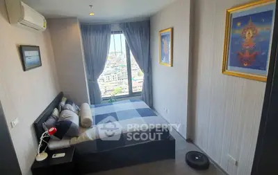 Modern bedroom with city view, featuring stylish decor and natural light.