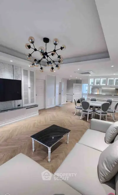 Luxurious open-plan living room with elegant chandelier and modern furnishings