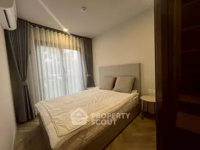 Cozy bedroom with modern decor and large window for natural light