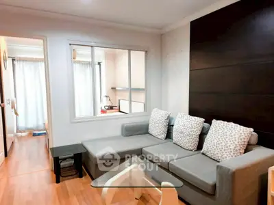 Modern living room with stylish gray sofa and glass coffee table in cozy apartment.