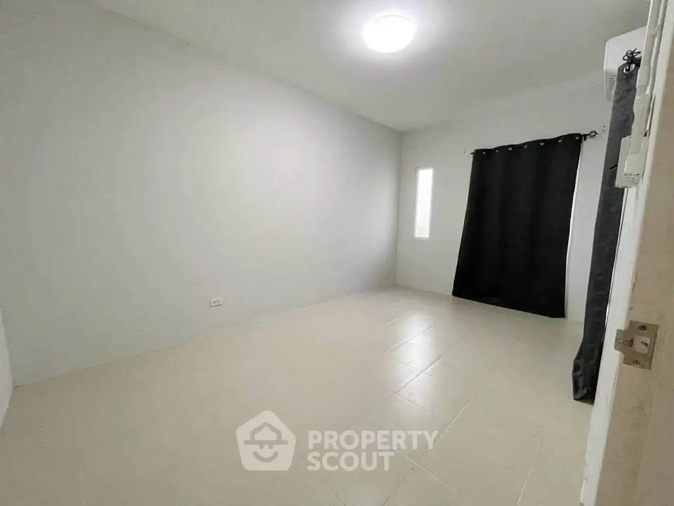 Spacious unfurnished room with tiled flooring and natural light, ideal for customization.