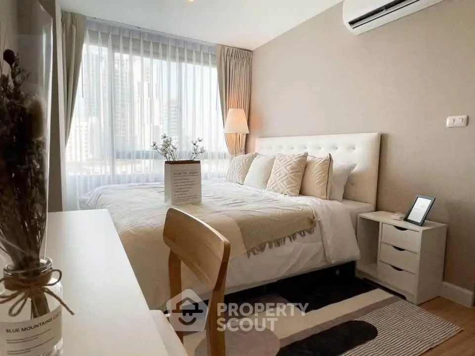 Modern bedroom with city view, featuring elegant decor and natural light, perfect for urban living.