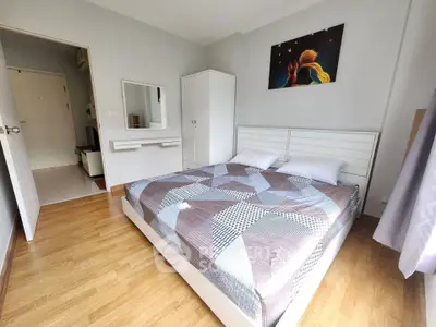Spacious bedroom with modern decor and wooden flooring in a stylish apartment.