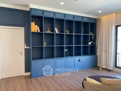Spacious living room with elegant blue built-in shelves and modern decor.