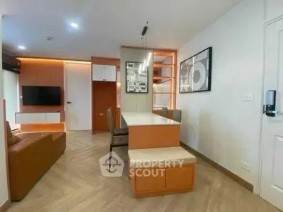 Modern living room with stylish decor and open layout, featuring a cozy seating area and contemporary artwork.