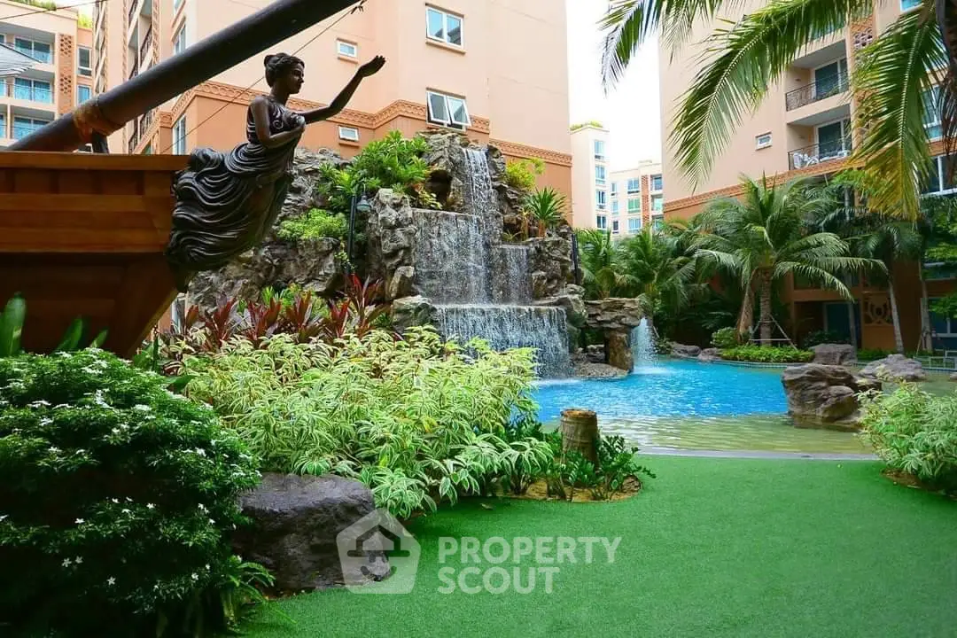 Luxurious tropical garden with waterfall and pool in upscale residential complex.