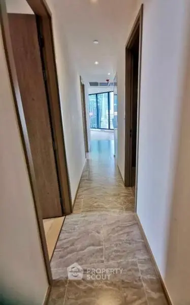 Modern apartment hallway with tiled flooring and natural light