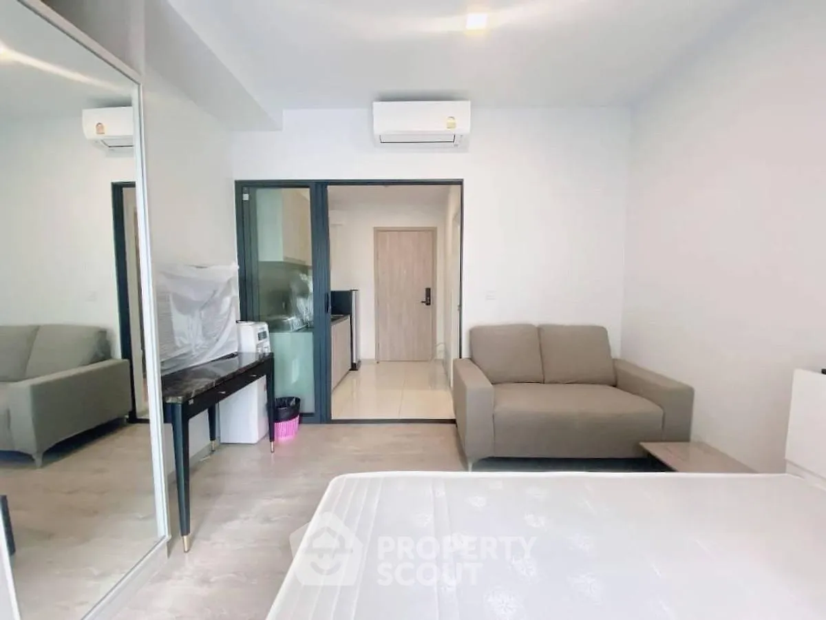 Modern studio apartment with mirrored closet and cozy sofa