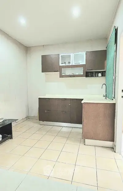 Spacious kitchen with modern cabinetry and tiled flooring in a cozy apartment.