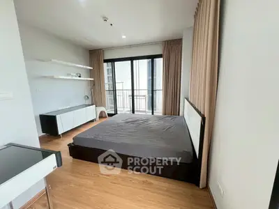 Modern bedroom with balcony access and sleek furnishings in a stylish apartment.