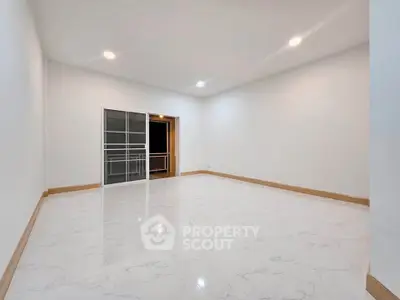 Spacious modern living room with sleek marble flooring and balcony access.