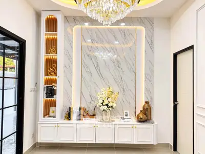 Luxurious interior with marble accent wall and elegant chandelier in modern home.