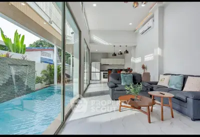 Luxurious living room with pool view and modern open kitchen layout